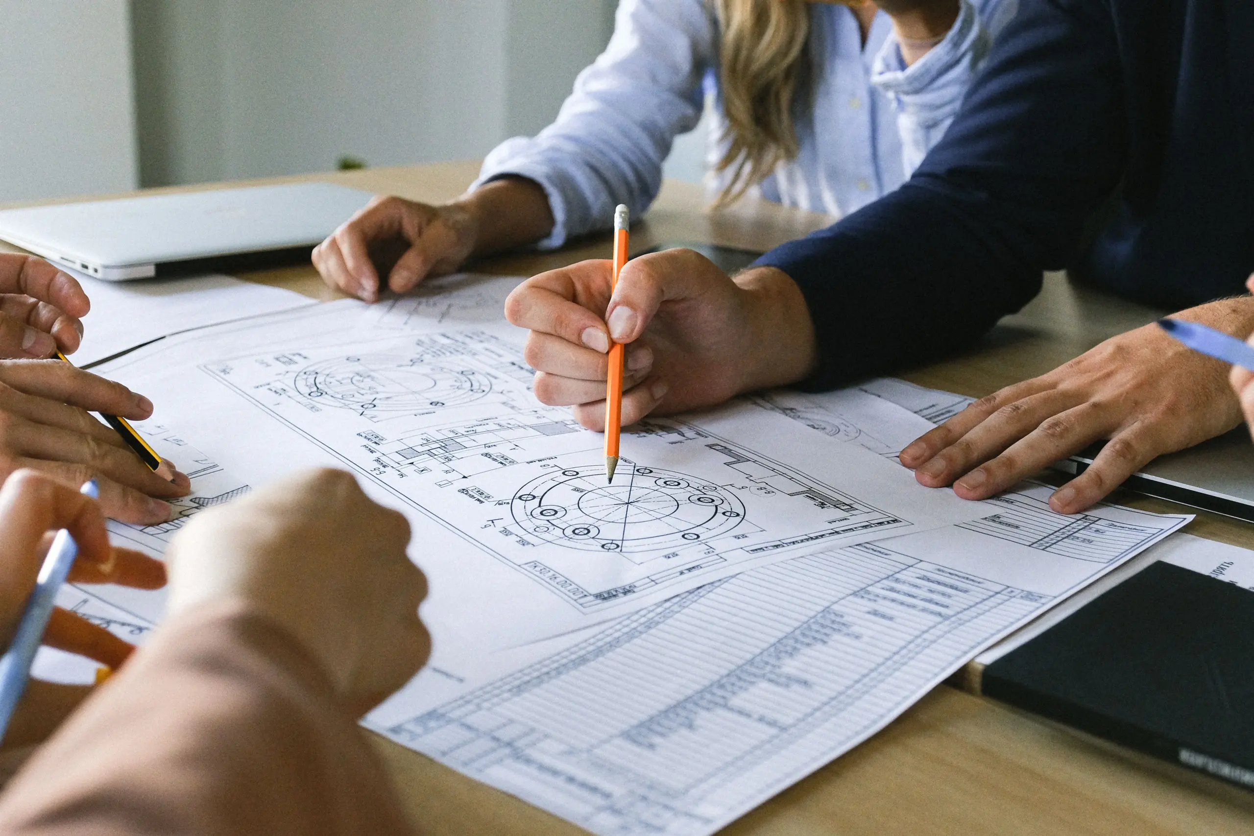 Mehrere Personen besprechen eine technische Zeichnung im Maschinenbau